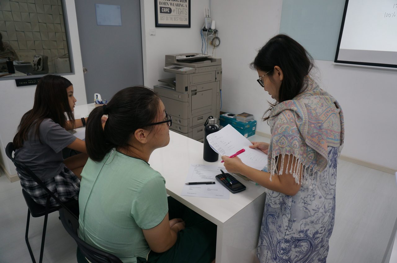 A Genius Plus Academy math tutor guiding a student through a problem